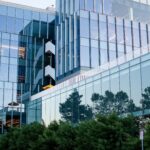 Corporate office exterior with trees outside reflected in glass