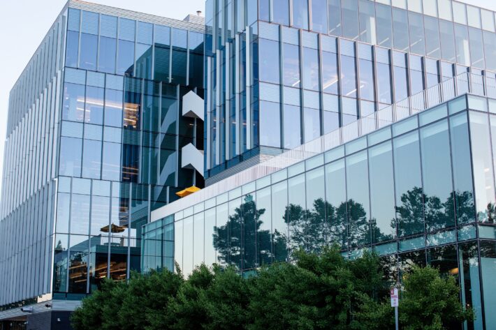 Corporate office exterior with trees outside reflected in glass
